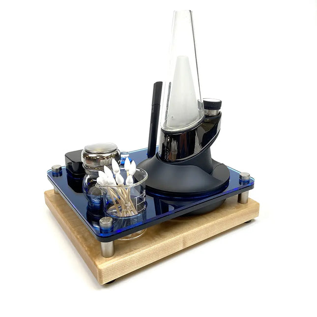 Desk organizer with glass containers and black cylindrical item on a wooden base