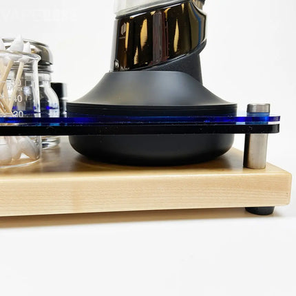 Black coffee grinder on a wooden stand with a white background